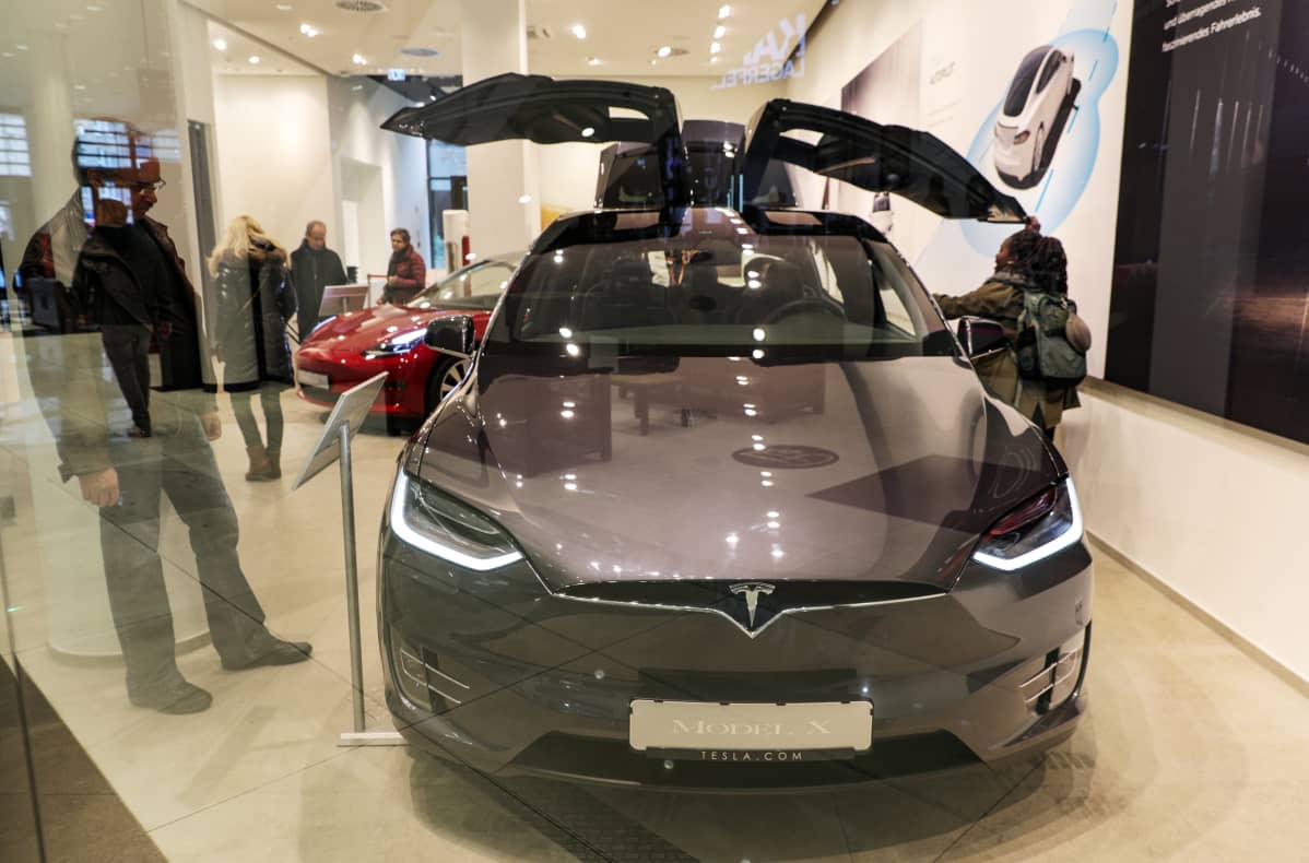 Kävijät katselevat Teslan autoa