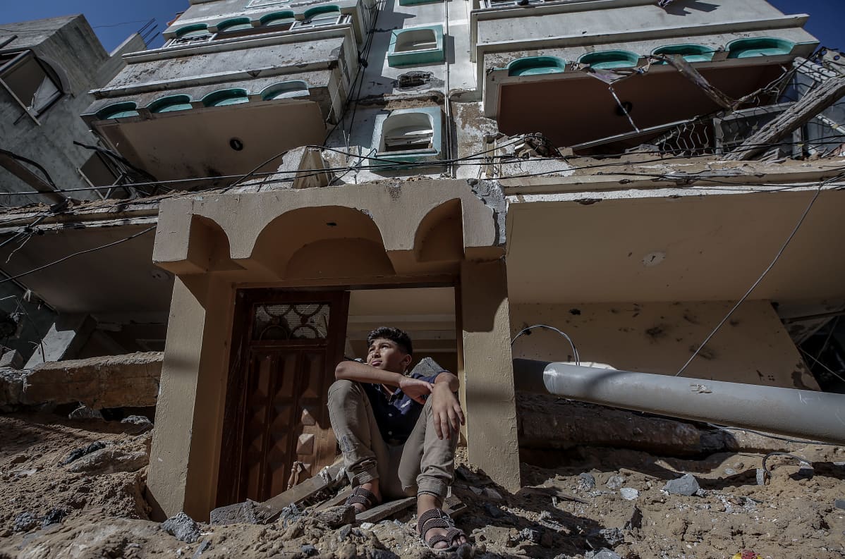 Palestiinalaispoika istuu Israelin pommittaman talon raunioilla Gazassa 13.5.2021.