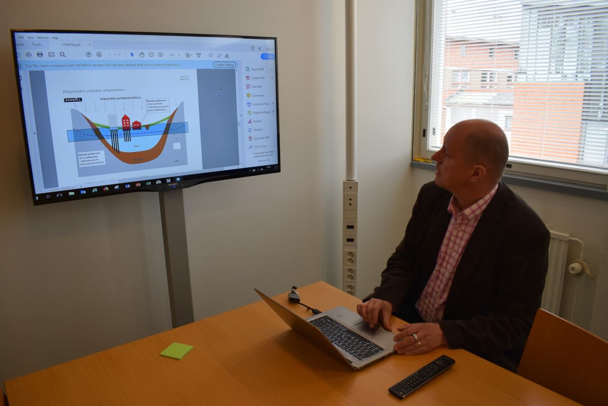 Professori Jussi Leveinen katsoo internetistä löytyvää raporttia Turun toriparkin suunnitelmista.