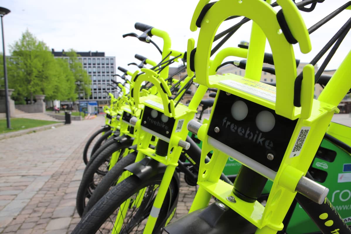 Rivissä neonvärisiä sähköpyöriä Hämeenlinnan torilla.