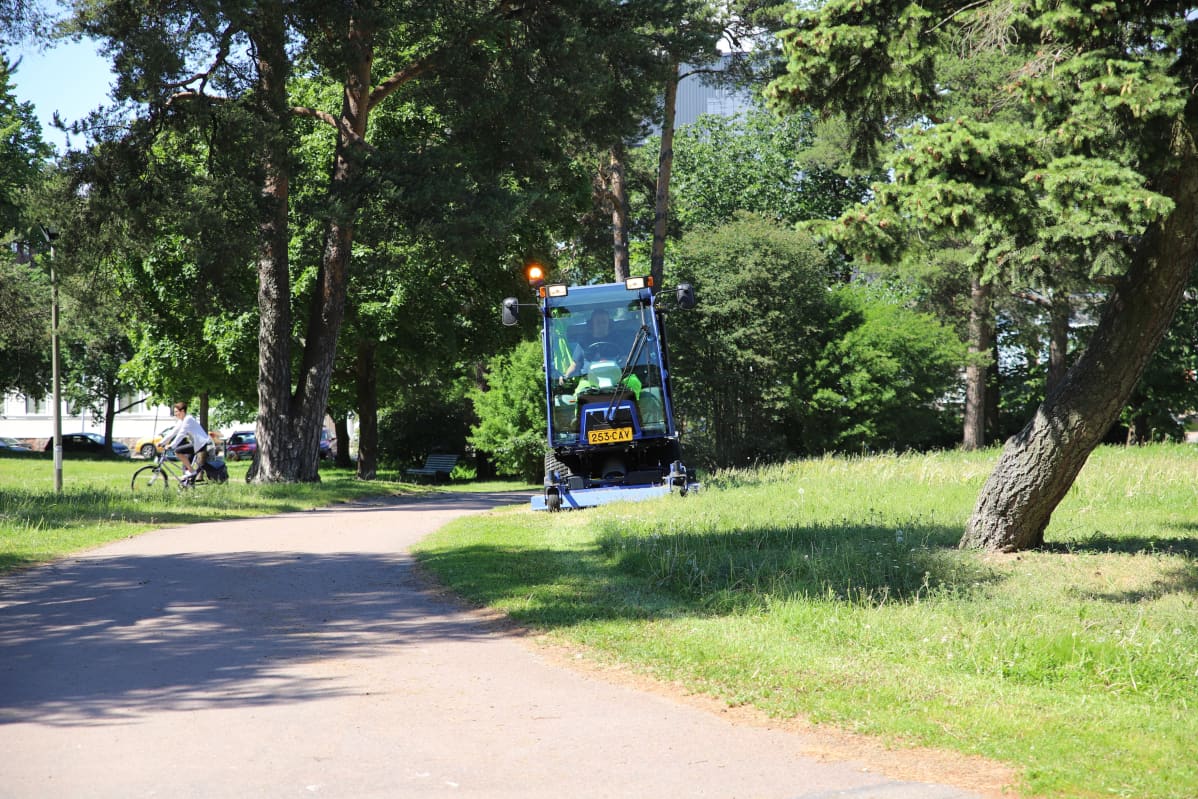 Ruohonleikkuukone ajamassa nurmea Isossapuistossa.
