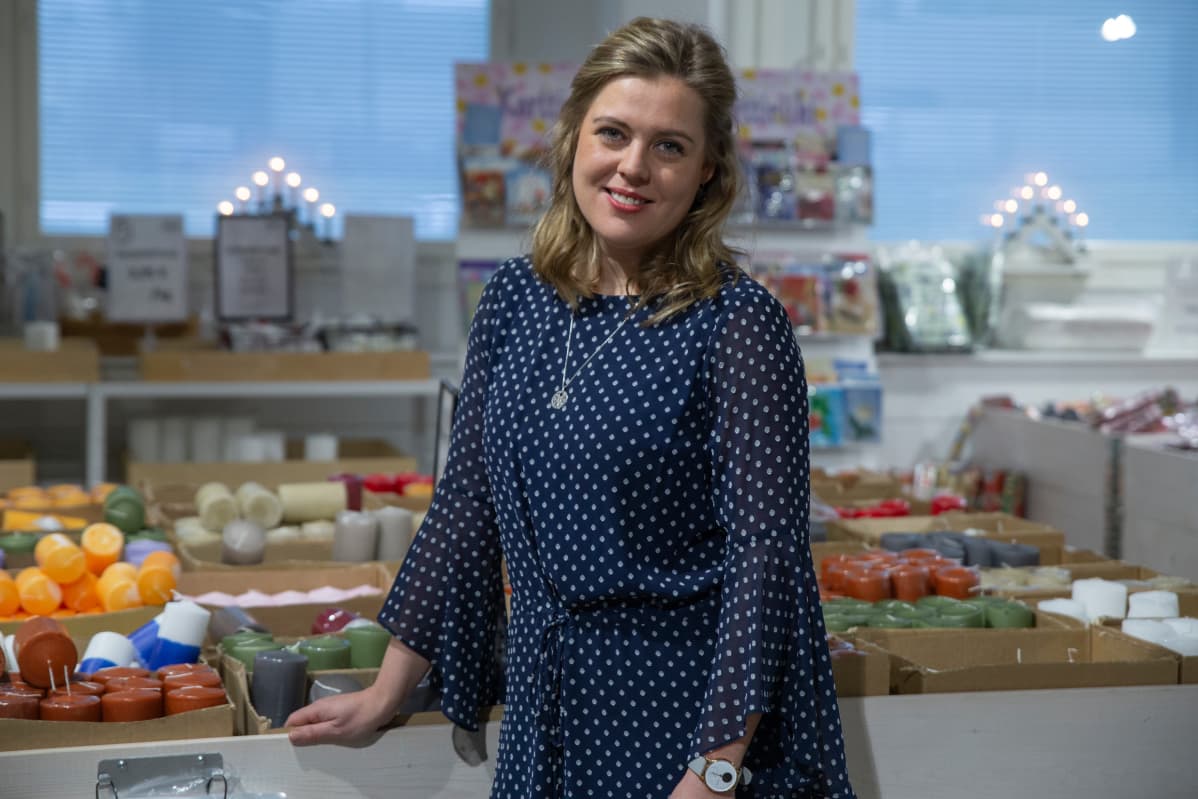 Linda Schlobohm aloitti Suomen vanhimman kynttilätehtaan toimitusjohtajana vajaat kaksi vuotta sitten. Kuvassa hän seisoo Riihimäen tehtaan myymälässä kynttilöiden keskellä.