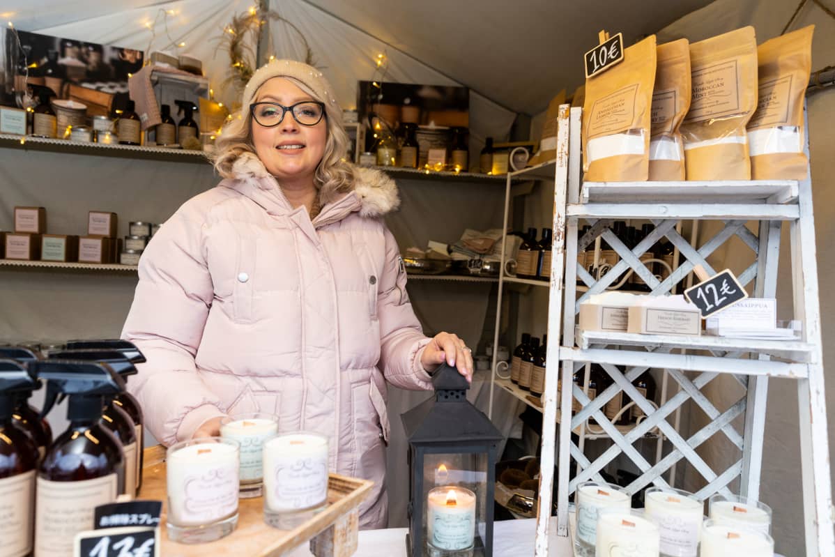 Annina Rosenström myyntikojussaan Tuomaan Markkinoilla Helsingissä. Lyhdyssä pöydällä palaa soijavahakynttilä.