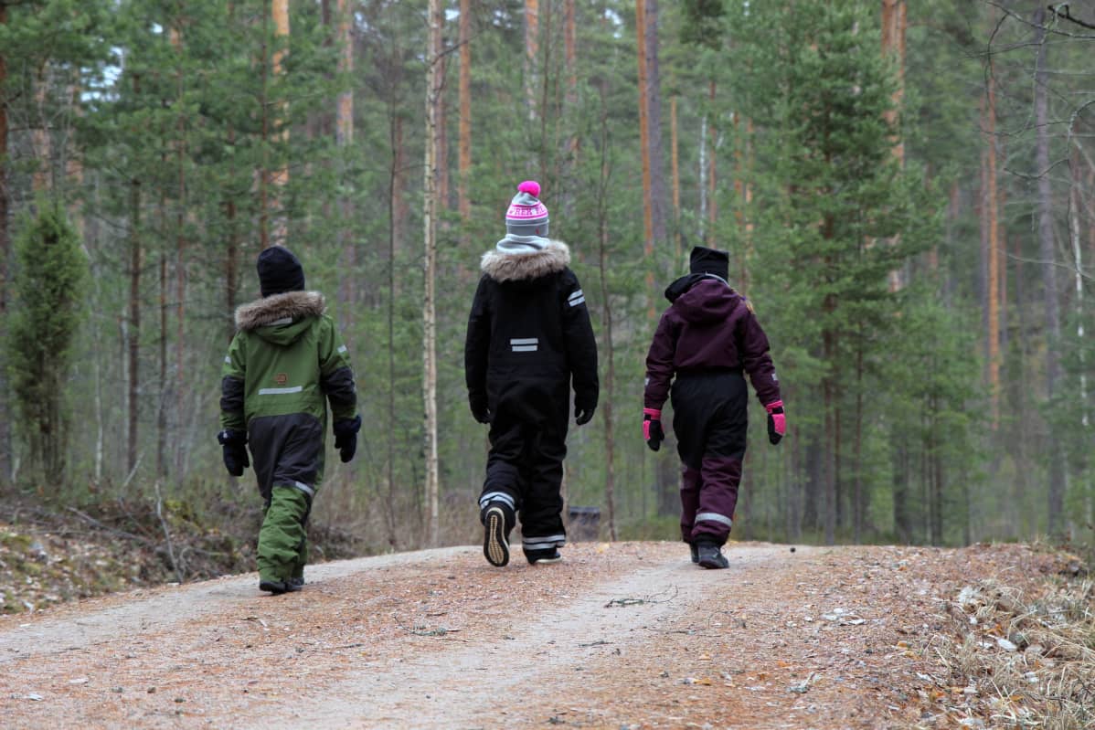 Lapsia metsässä kävelemässä.