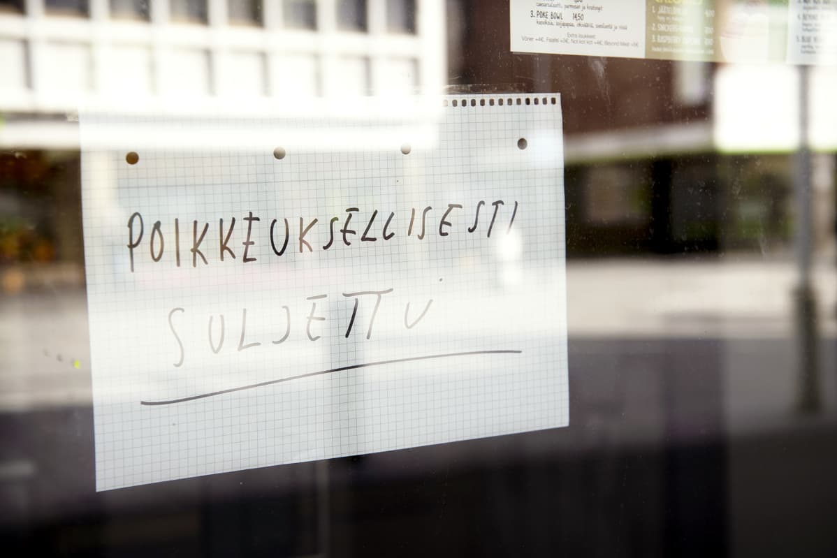 Poikkeuksellisesti suljettu -lappu ravintolan ikkunassa.