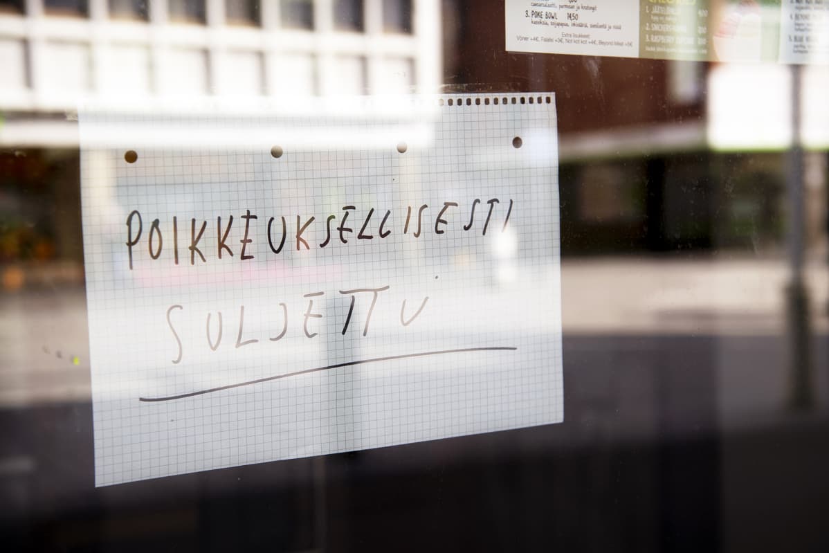 Poikkeuksellisesti suljettu -lappu ravintolan ikkunassa.