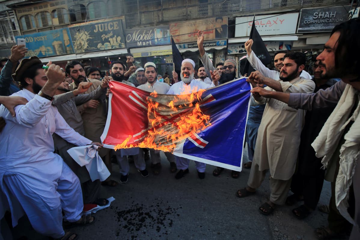 Pakistani people burn a mock of a French flag during a demonstration against French President Macron's comments over Prophet Muhammad caricatures, in Peshawar, Pakisan, 26 October 2020. A group of protestors gathered to protest Macron's comments following the recent beheading of a teacher in France, after he had shown caricatures of the Prophet Muhammad in class. Macron vowed his country would not give up publishing such cartoons. EPA-EFE/ARSHAD ARBAB