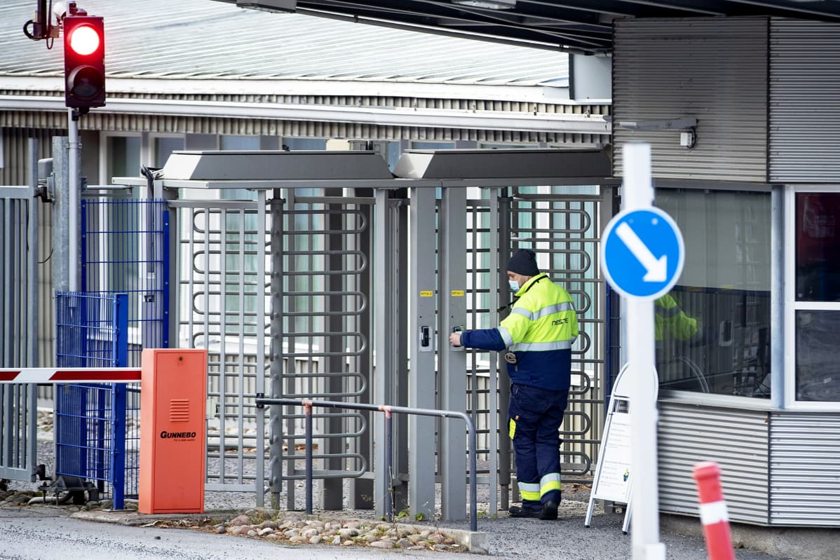 Työntekijä Nesteen Naantalin jalostamon pääportilla.