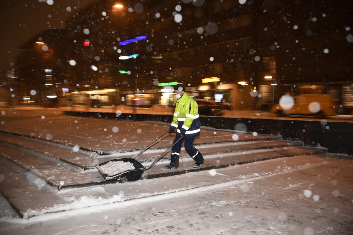 Mies kolaa lunta Kampintorilla.
