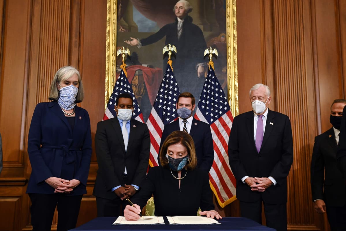 Nancy Pelosi allekirjoittaa virkasyyteasiakirjan.