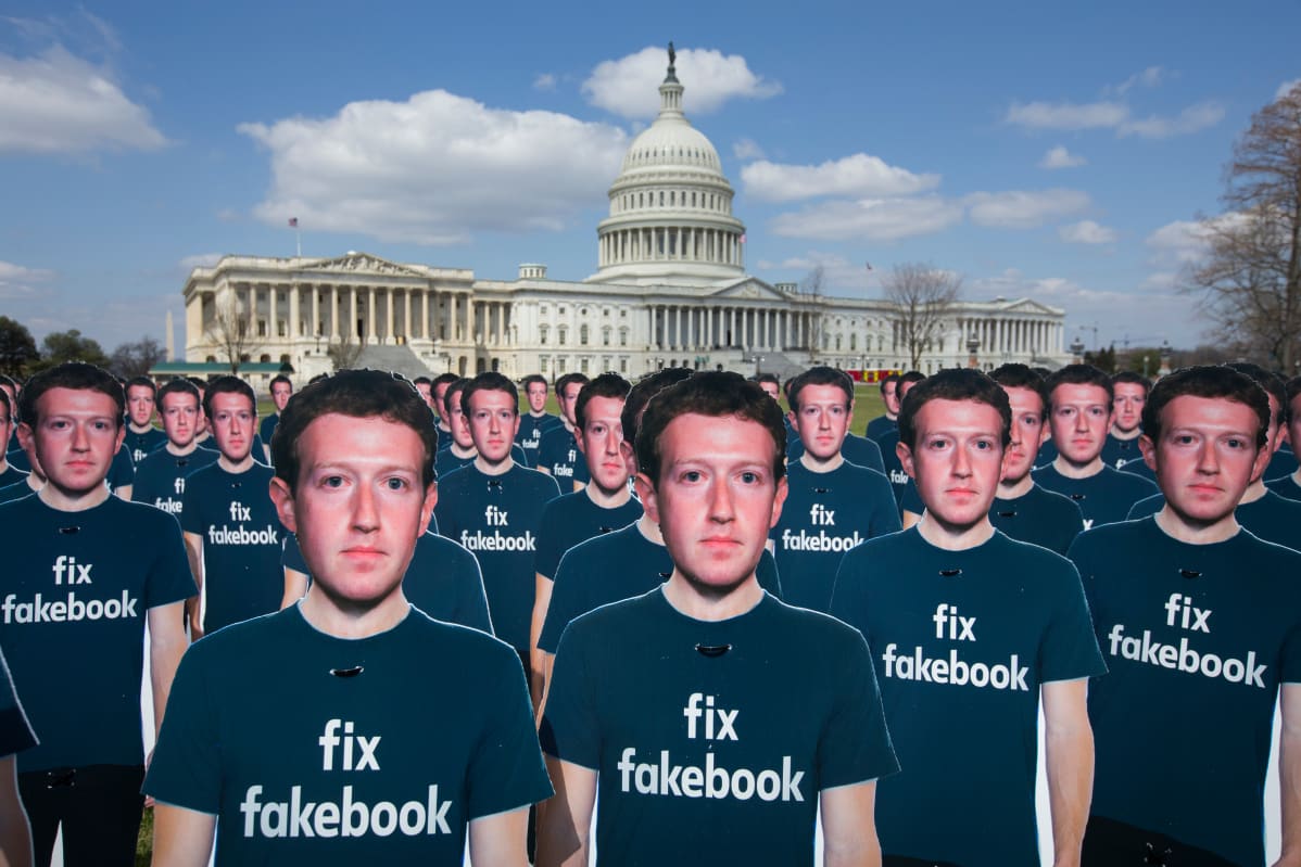 Mark Zuckerbergin pahvihahmojen t-paidoissa lukee teksti "fix fakebook". Yhdysvaltain kongressirakennus taustalla.