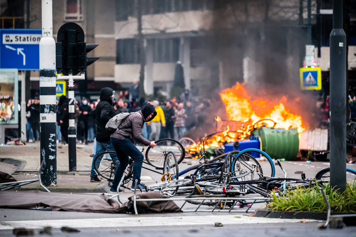 Hollannissa mellakoitiin koronarajoituksia vastaan. Polkupyöriä rikotaan ja taustalla poltetaan jotain.