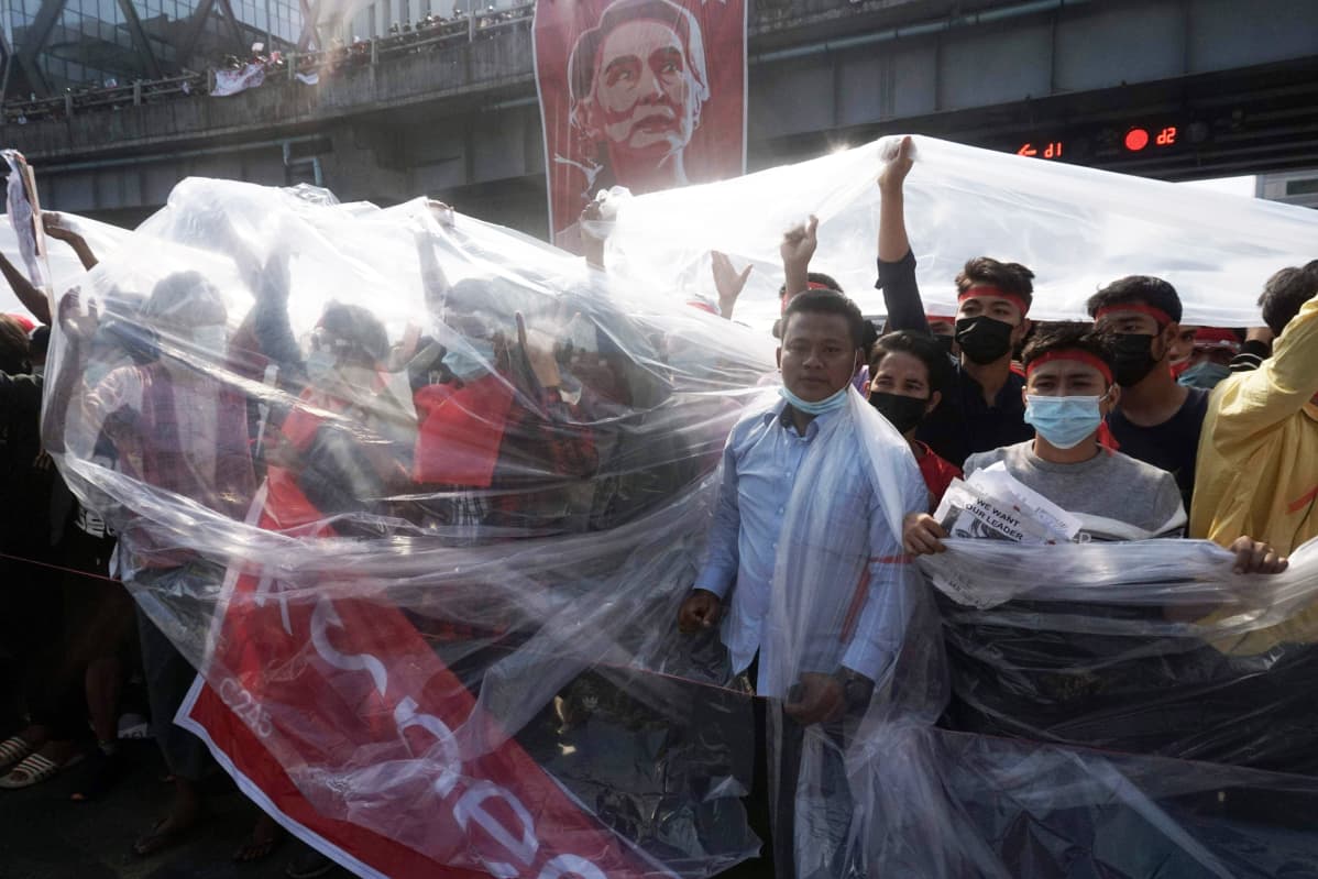 Mielenosoittajat suojautuvat muoveilla Yangonissa.