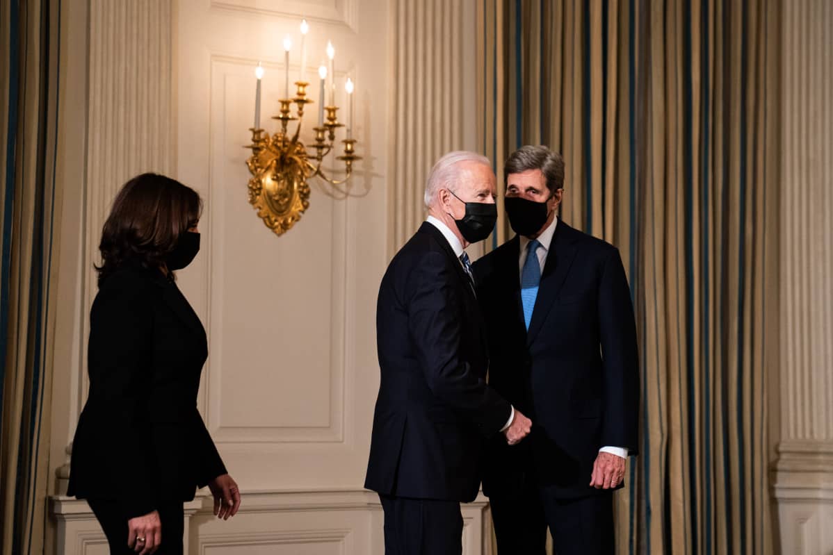 Biden ja Kerry keskustelevat maskit kasvoillaan, Harris hieman taaempana.