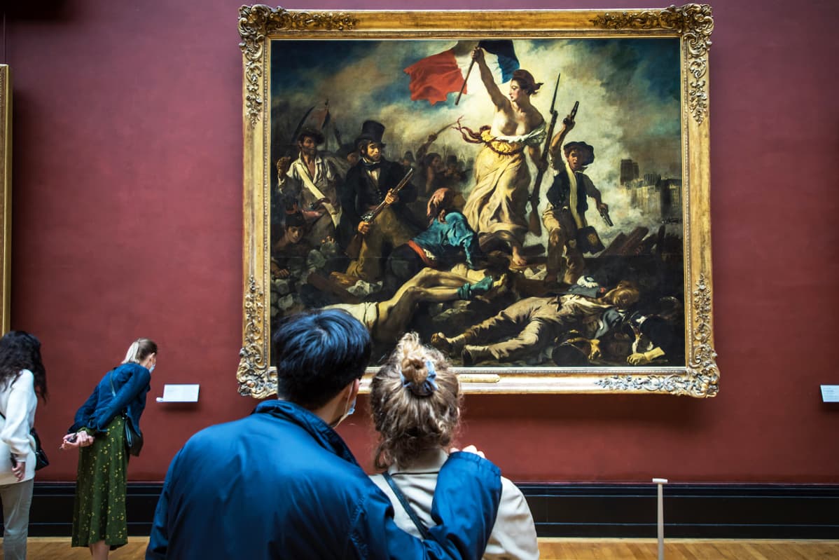 Museovieraat katselevat vallankumousta esittävää maalausta Louvressa.