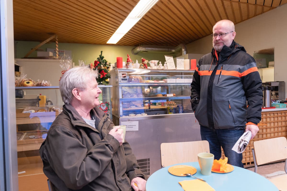 Jari Lindström keskustelee kahvilassa Aki Haimin kanssa