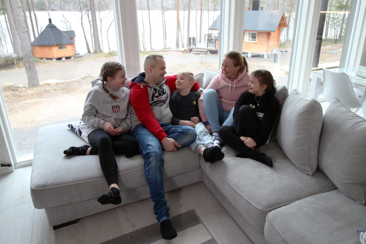 Hahlien perhe istumassa sohvalla.