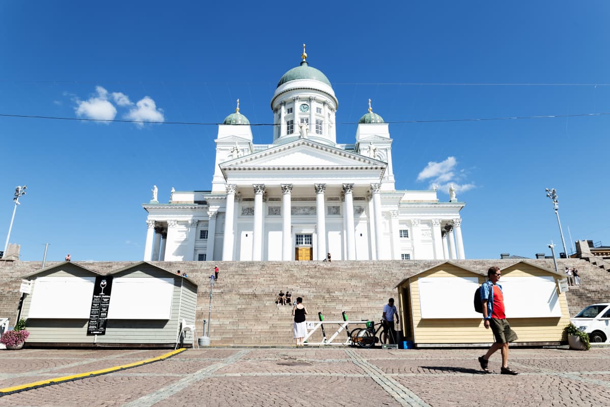 Tuomiokirkko kylpee auringossa senaatintorilla, koronakesän takia rappusilla on vain pari ihmistä.