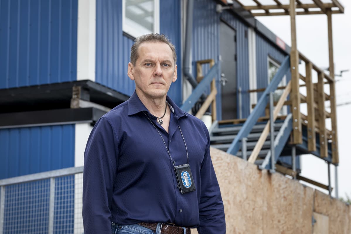 Kortelainen seisoo työmaakonttien edessä.