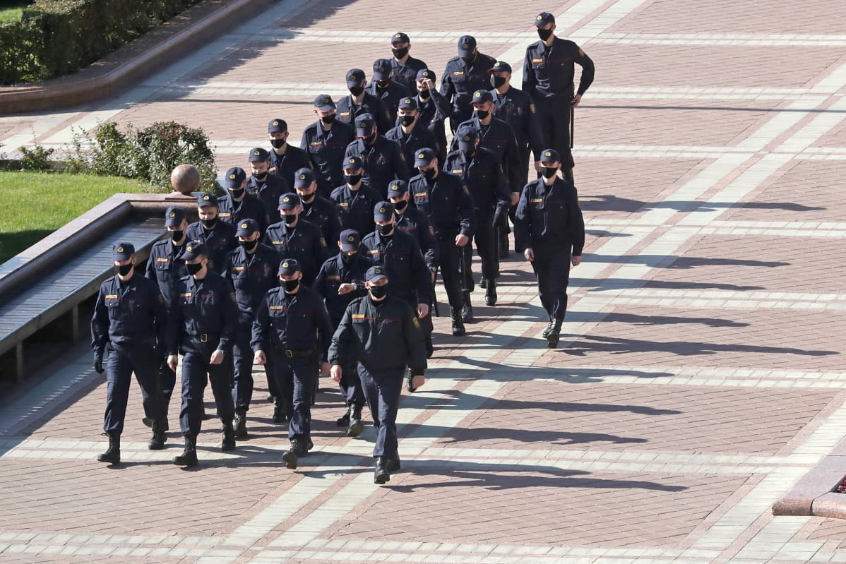 Poliisit marssivat muodostelmassa.