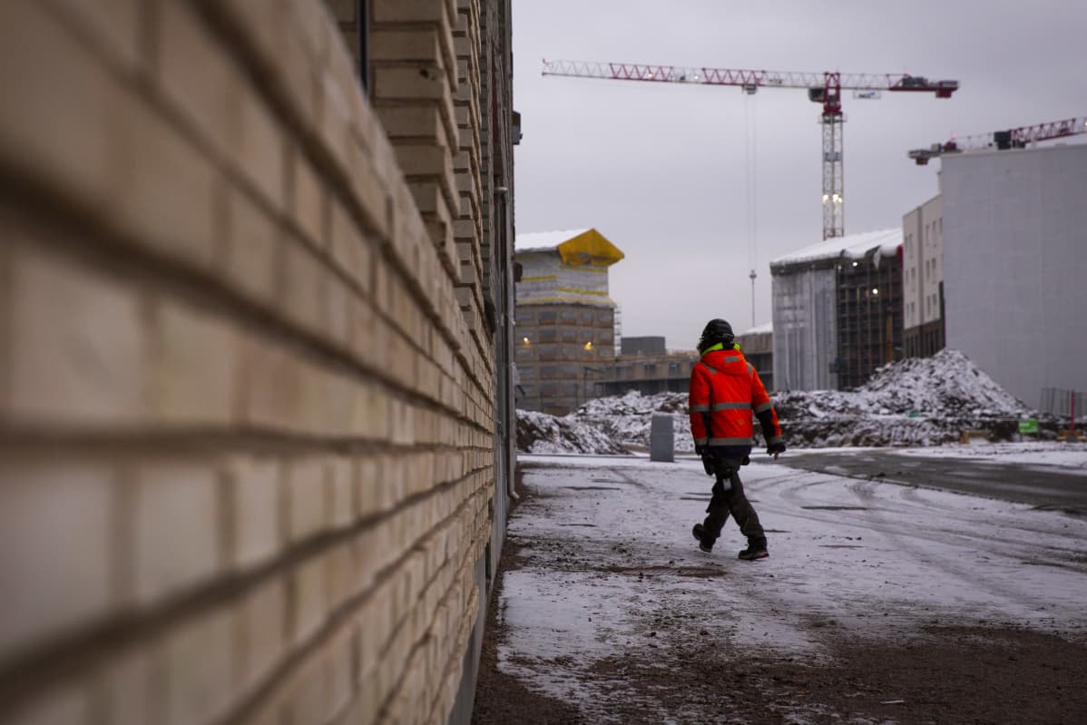 Mies kävelee rakennustyömaalla.