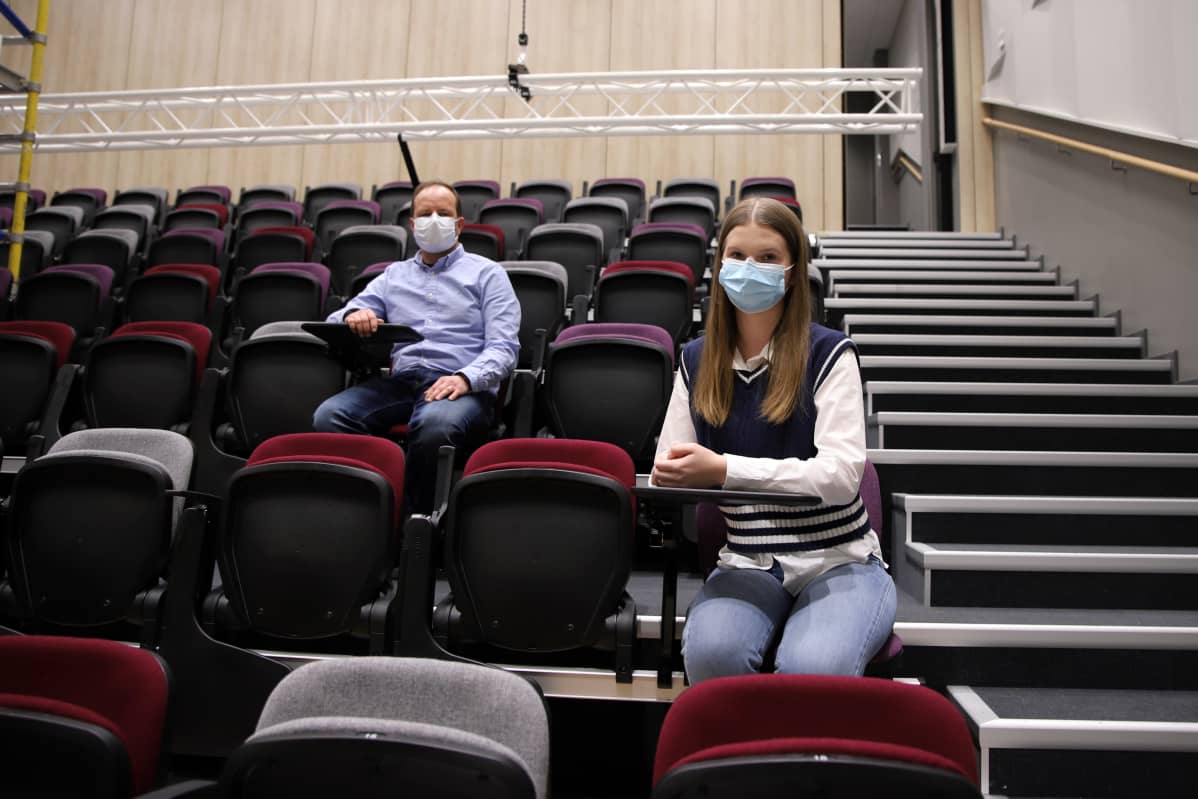 Kaksi ihmistä istuu auditoriossa