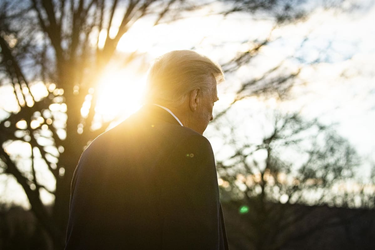 Donald Trump kuvattuna selkäpuolelta vastavaloon.