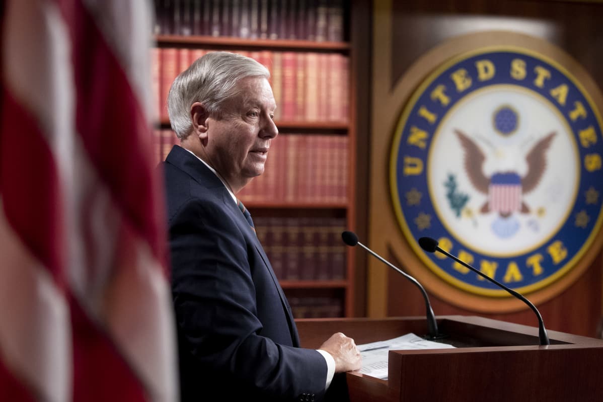 Republikaanisenaattori Lindsey Graham puhuu. Kuvassa näkyy myös USA:n lippu.