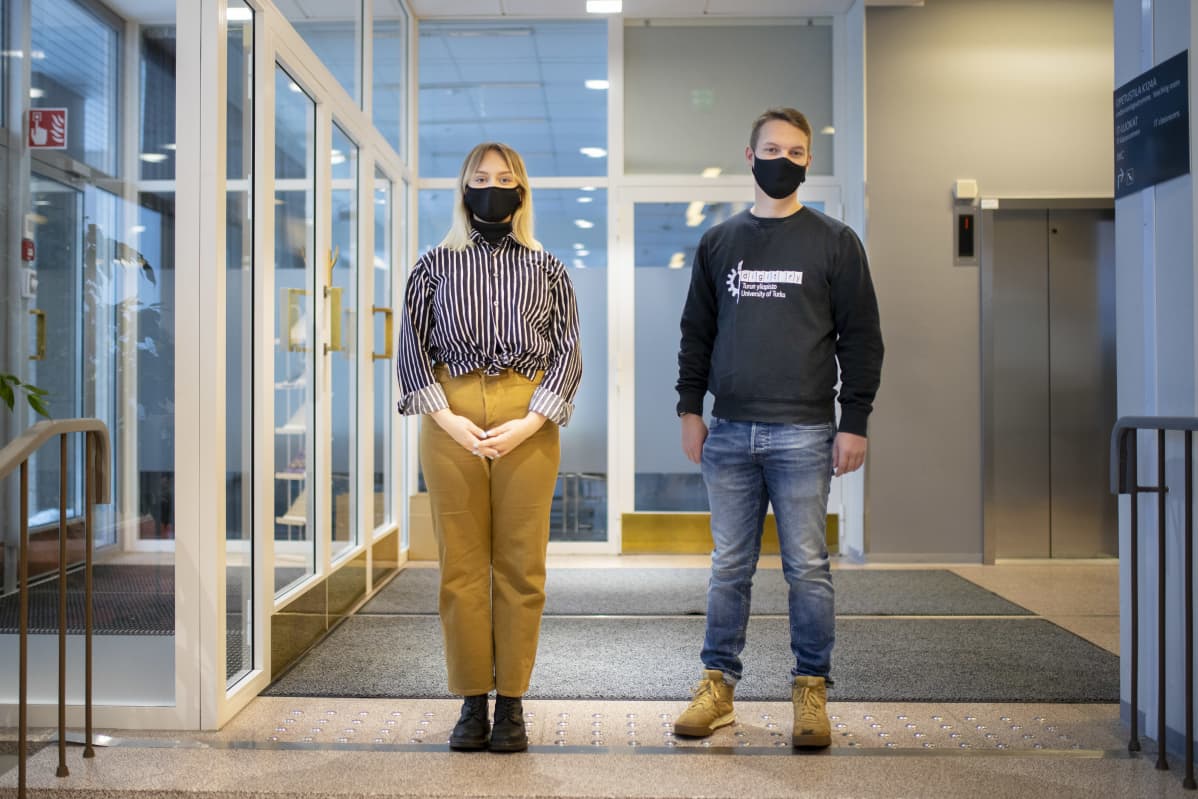 Tekniikan opiskelijat Miika Peltotalo ja Katriina McCormick istuvat Turun yliopiston Agora-rakennuksen aulassa.