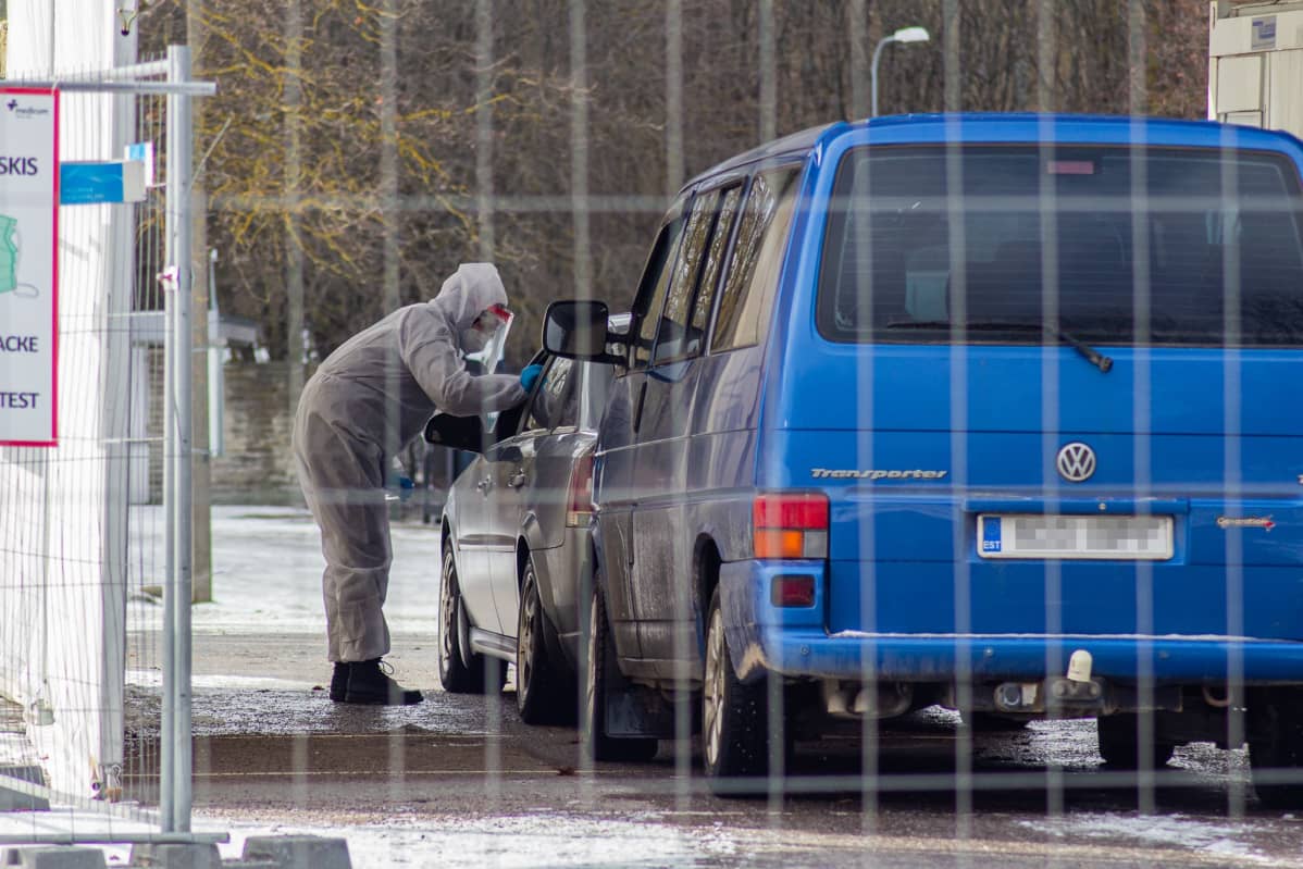 Hoitaja ottaa nenänielunäytteen tallinnalaisessa draiv in testauspaikalla Virossa.