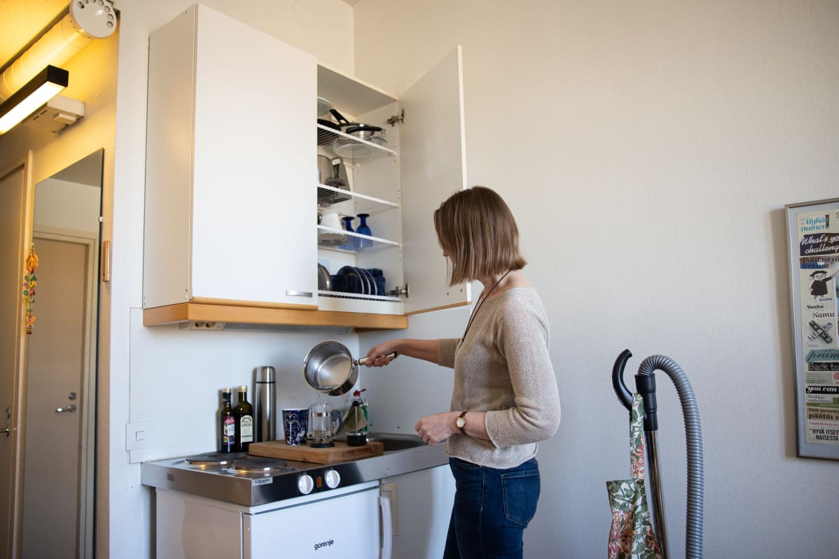 Saila Suominen kaataa kattilasta vettä minikeittiössään.