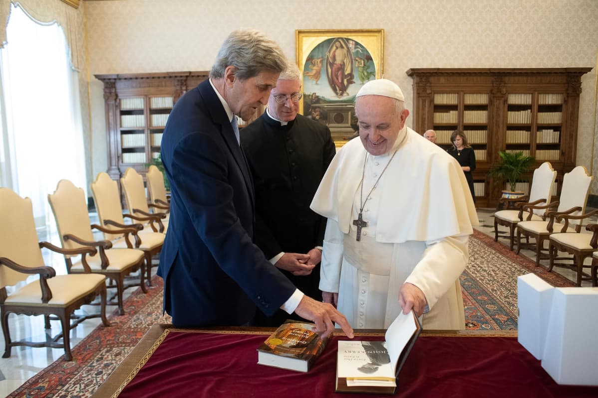 John Kerry osoittaa kirjan sivua paaville.