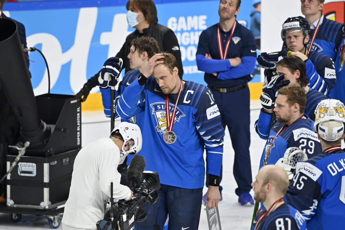 Suomen kapteeni Marko Anttila haroi hiuksiaan hopeamitali kaulassa.