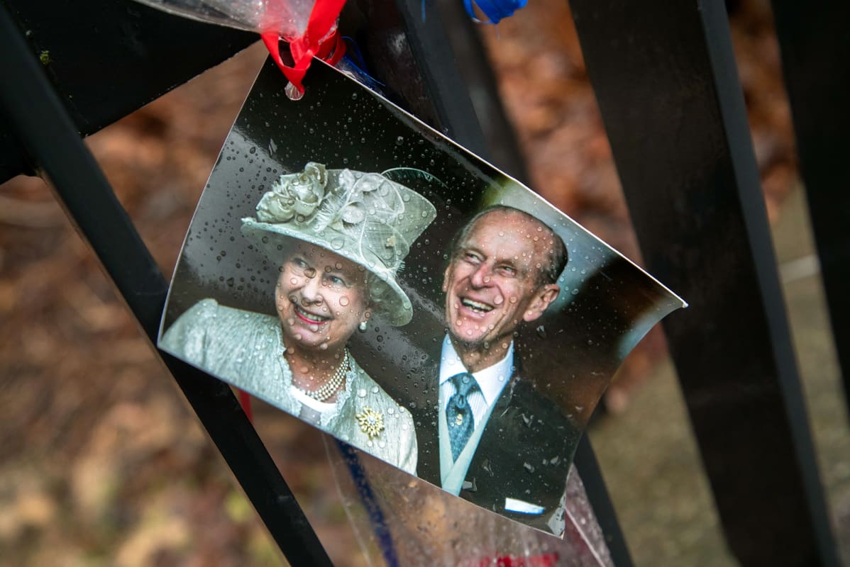 Kuningatar Elisabetia ja prinssi Philipiä esittävä valokuva kiinnitettynä Britannian suurlähetystön aitaan Helsingissä.