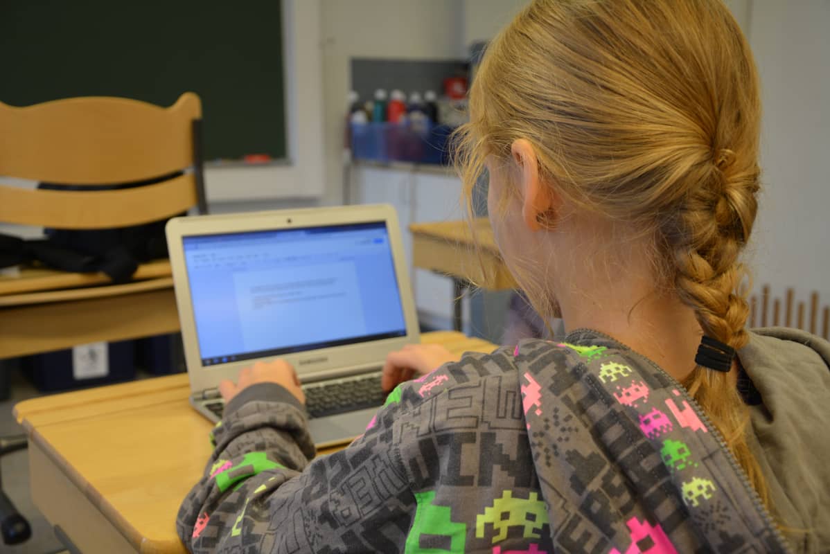 Oppilas käyttää kannettavaa tietokonetta