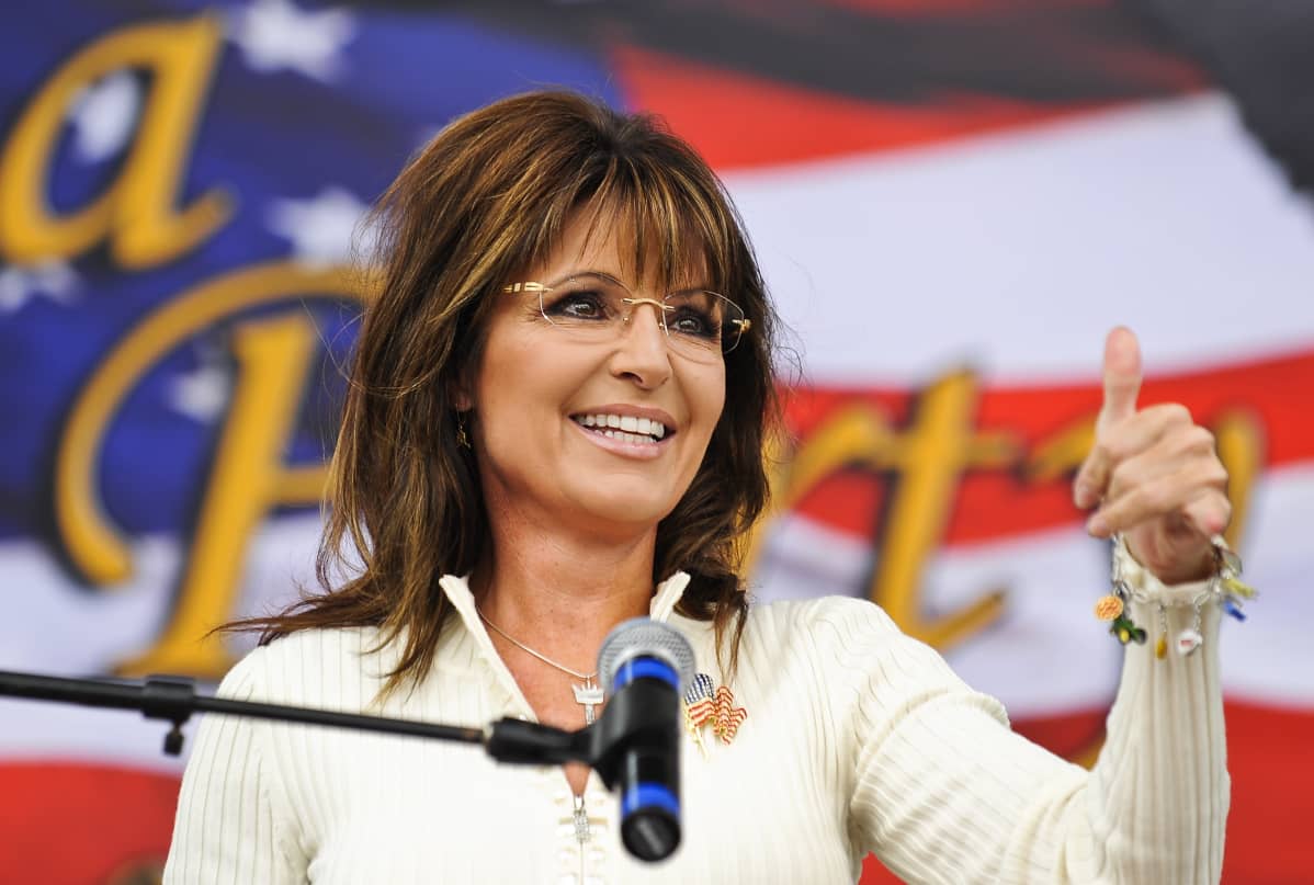 Sarah Palin lähikuvassa näyttää peukkua teekutsuliikkeen tilaisuudessa.