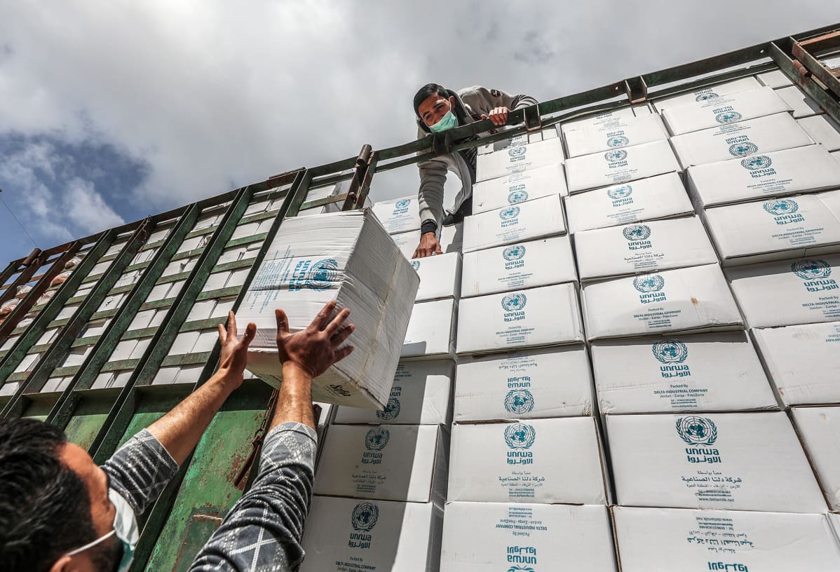 UNRWA:n työntekijät lastaavat avustustarvikkeita kuorma-autoon Gazan kaupungissa huhtikuussa 2020.