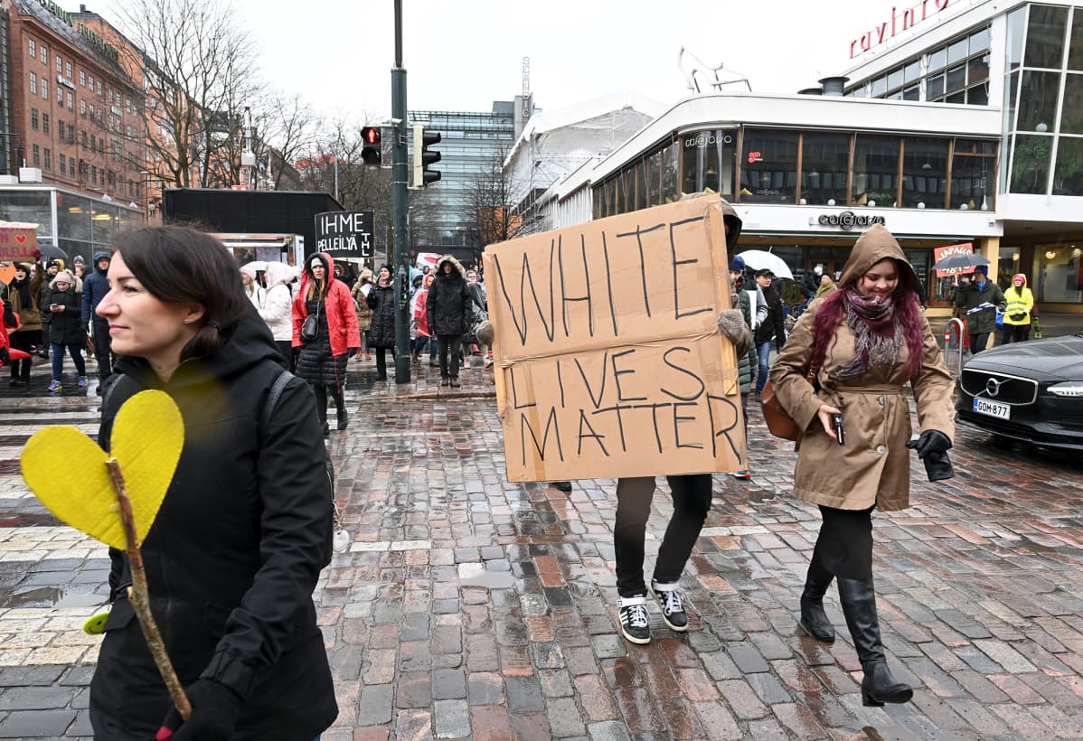 White lives matter -pahvikylttiä kantava mielenosoittaja.