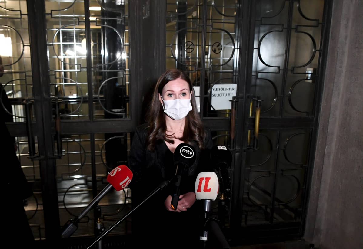 Statsminister Sanna Marin (SDP) svarar på journalisters frågor utanför riksdagen den 21 december 2020.