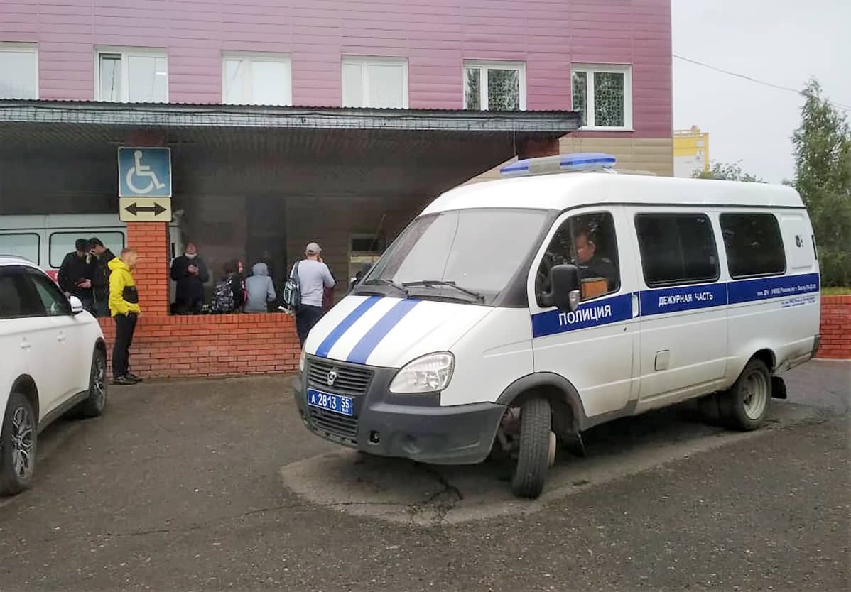 Poliisin pikkubussi seisoo sairaalan edessä. Äsken on satanut, auton alla on kuiva kohta,