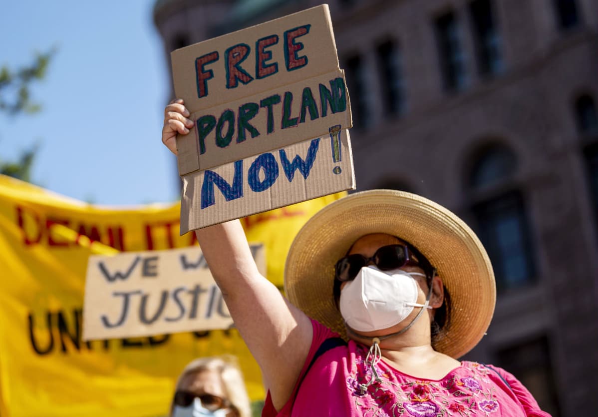 Vapauttakaa Portland -kylttiä kantava mielenosoittaja Minneapolisissa.