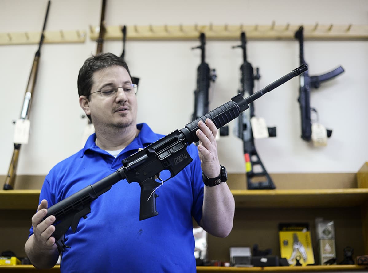 CJI Guns-asellikkeen omistaja Ron Moon esittelee Smith&Wesson MP15-tyyppistä puoliautomaattikivääriä.