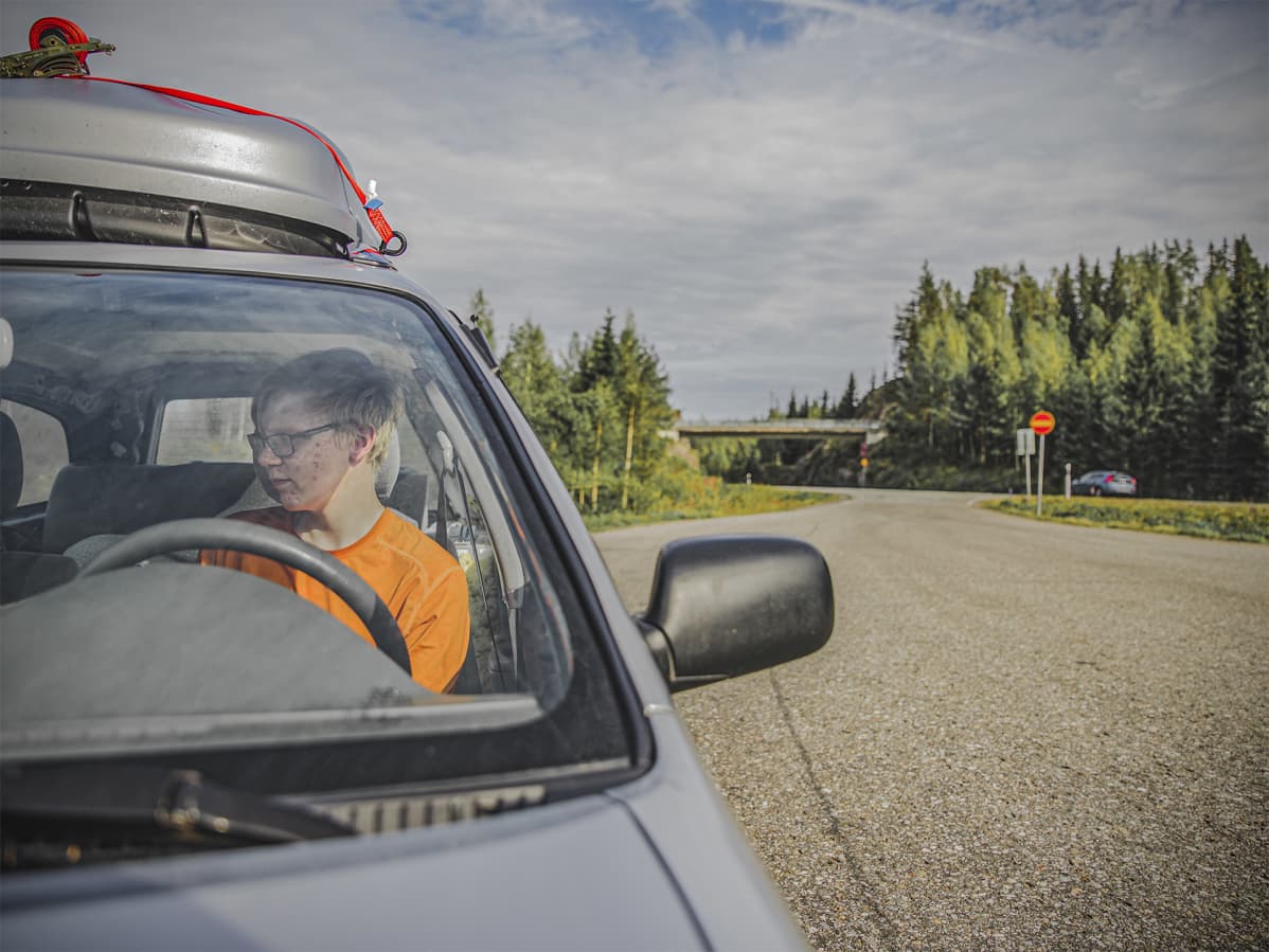 Saku istuu autossaan ja viitostie kulkee ihan vierestä.