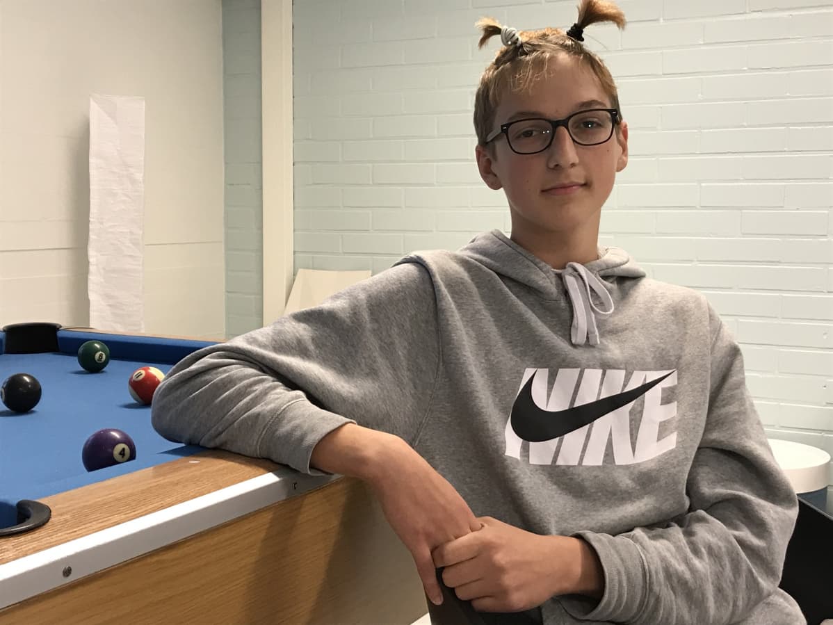 Joa Leiman istuu ja nojaa toista kättä biljardipöytään.