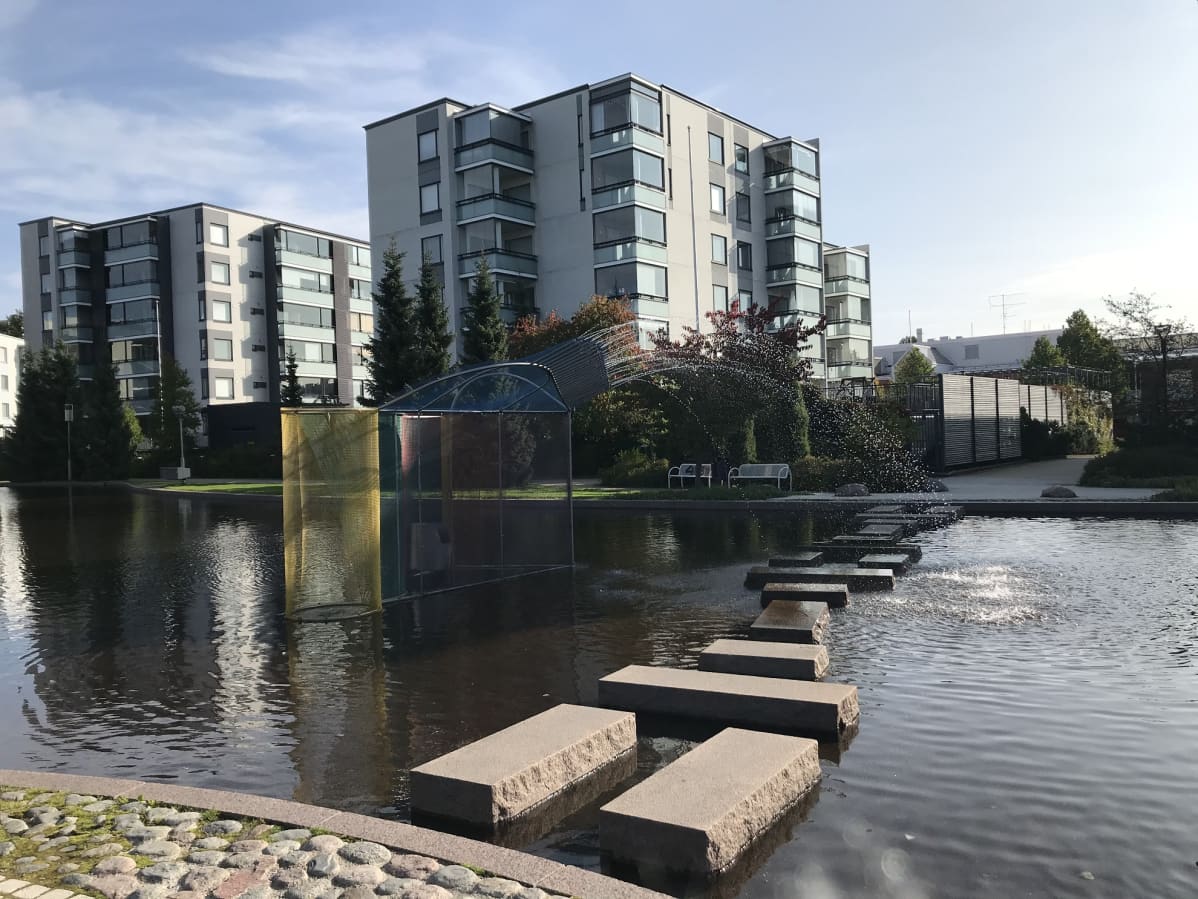 Kerrostaloja Keravan kirjaston lähellä, etualalla on suuri vesiallas.