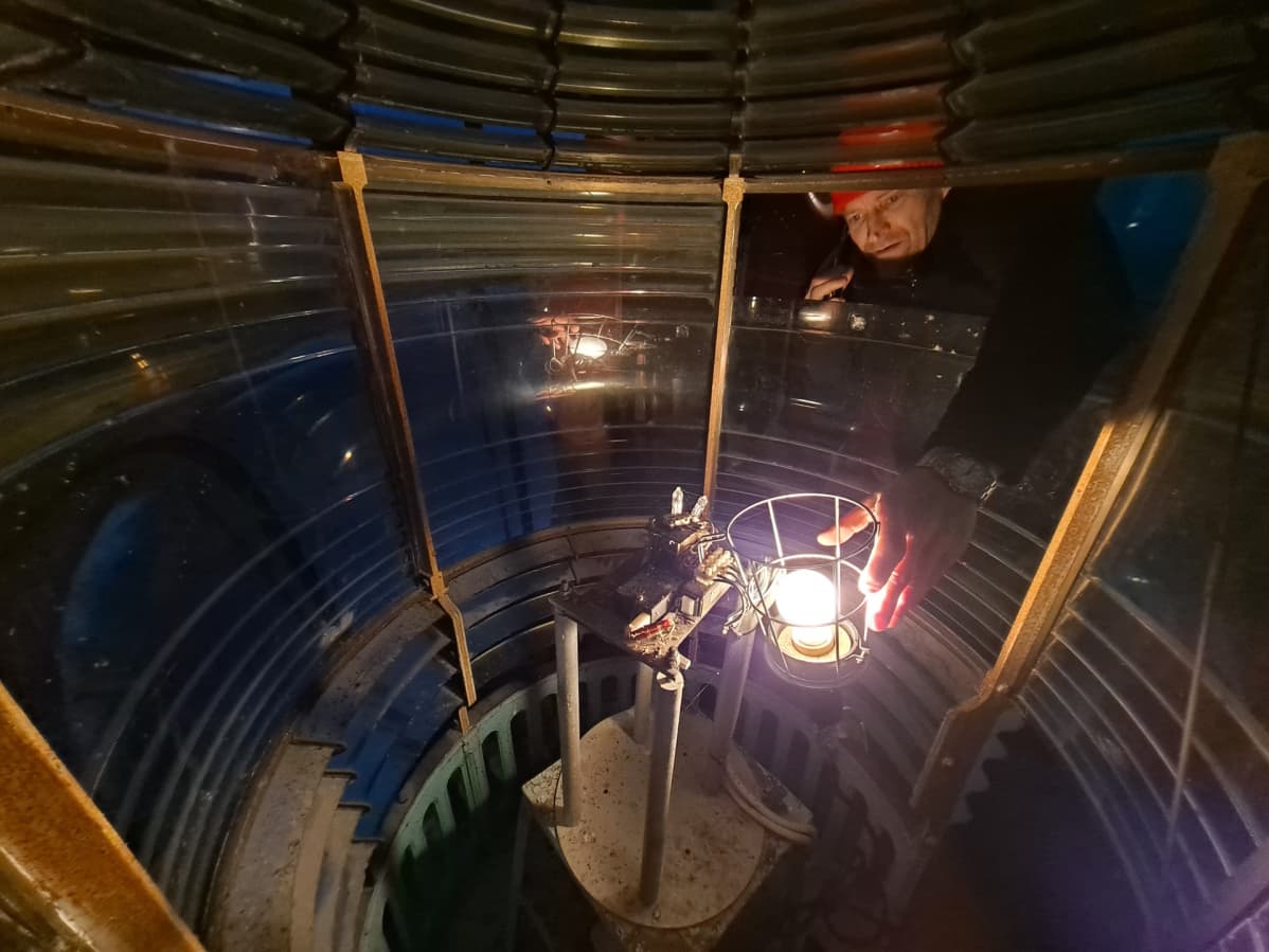 Kallbådan isäntä Veikka Gustafsson asettaa symbolisesti valon alkuperäiselle paikalle Kallbådan majakan lyhtykojussa.