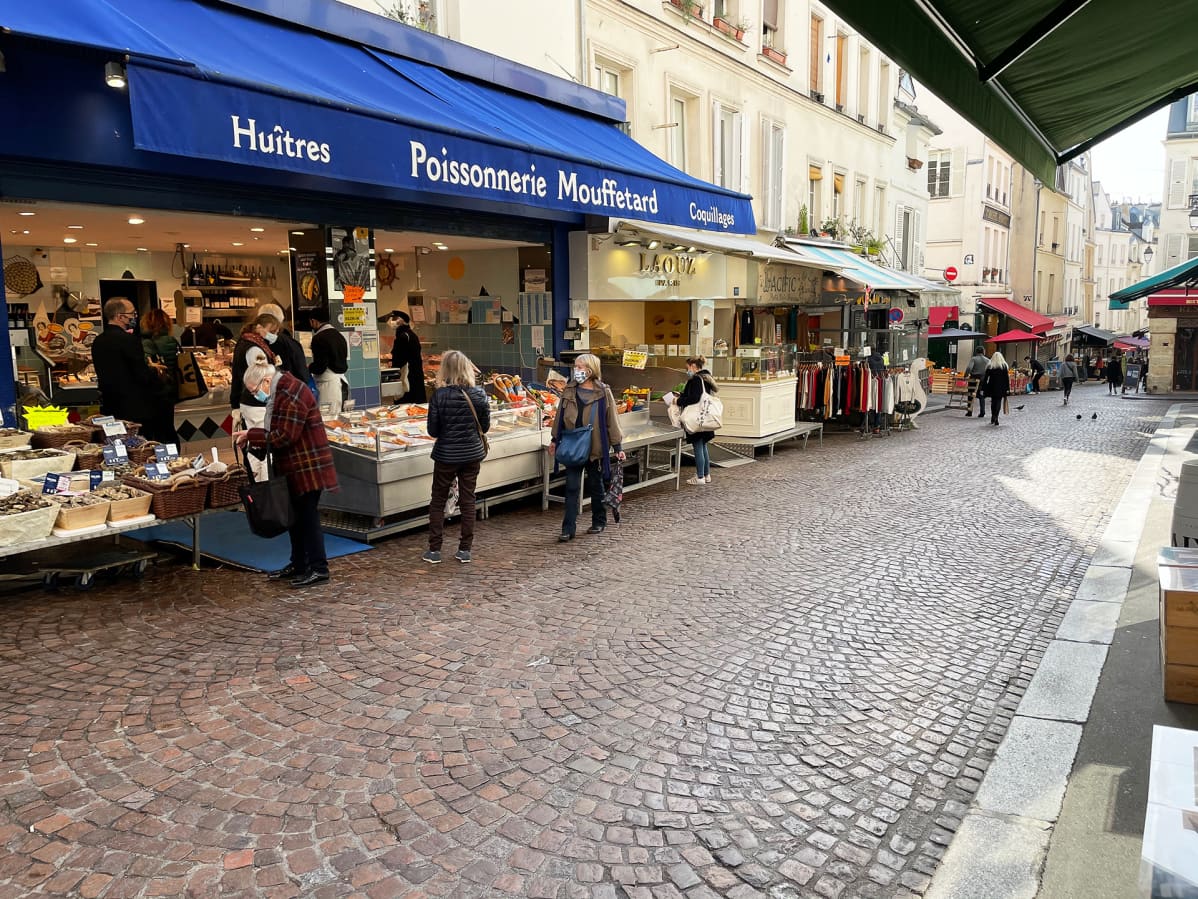 Asiakkaat odottelevat tässä hyvin turvavälein vuoronaan rue Mouffetardin eräällä kalakauppiaalla. Useimmiten välit ovat vähän miten sattuu.