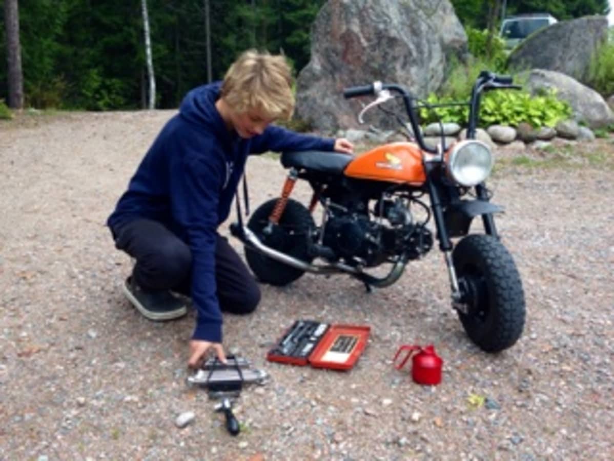 Vuolenkoskelainen teinipoika rassaa mopoaan.