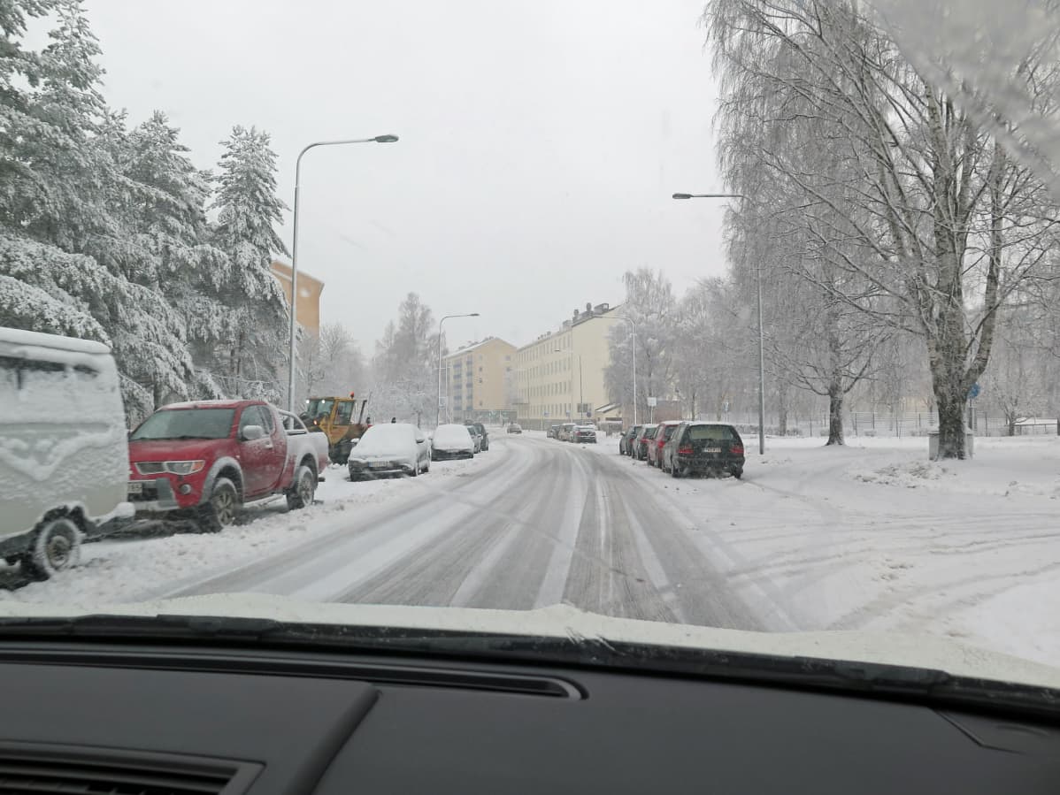 Luminen tie, jonka varrelle on pysäköity autoja