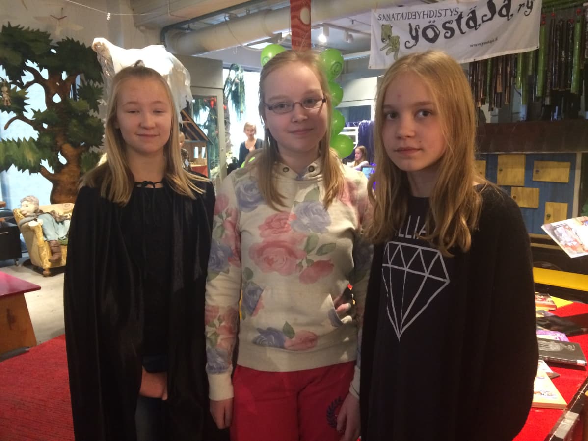 Kolme tyttöä katsoo kameraa lasten tapahtumassa Tampereella.